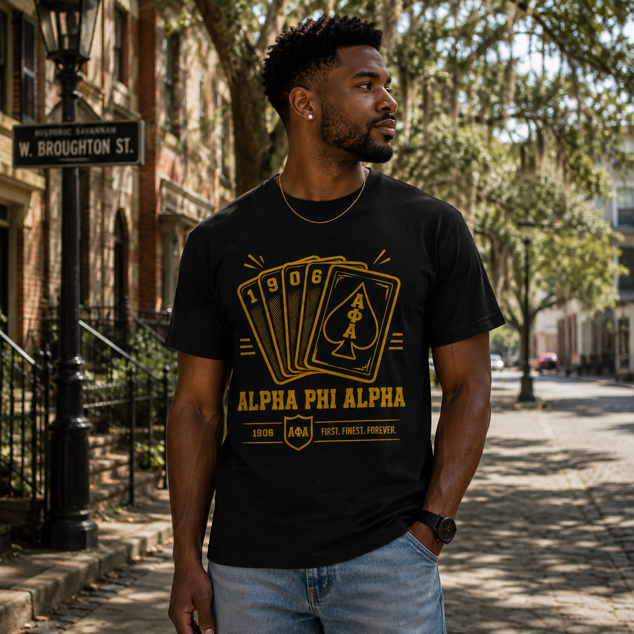 Model wearing the Alpha Phi Alpha 1906 Playing Cards black T-shirt with gold ΑΦΑ card graphic