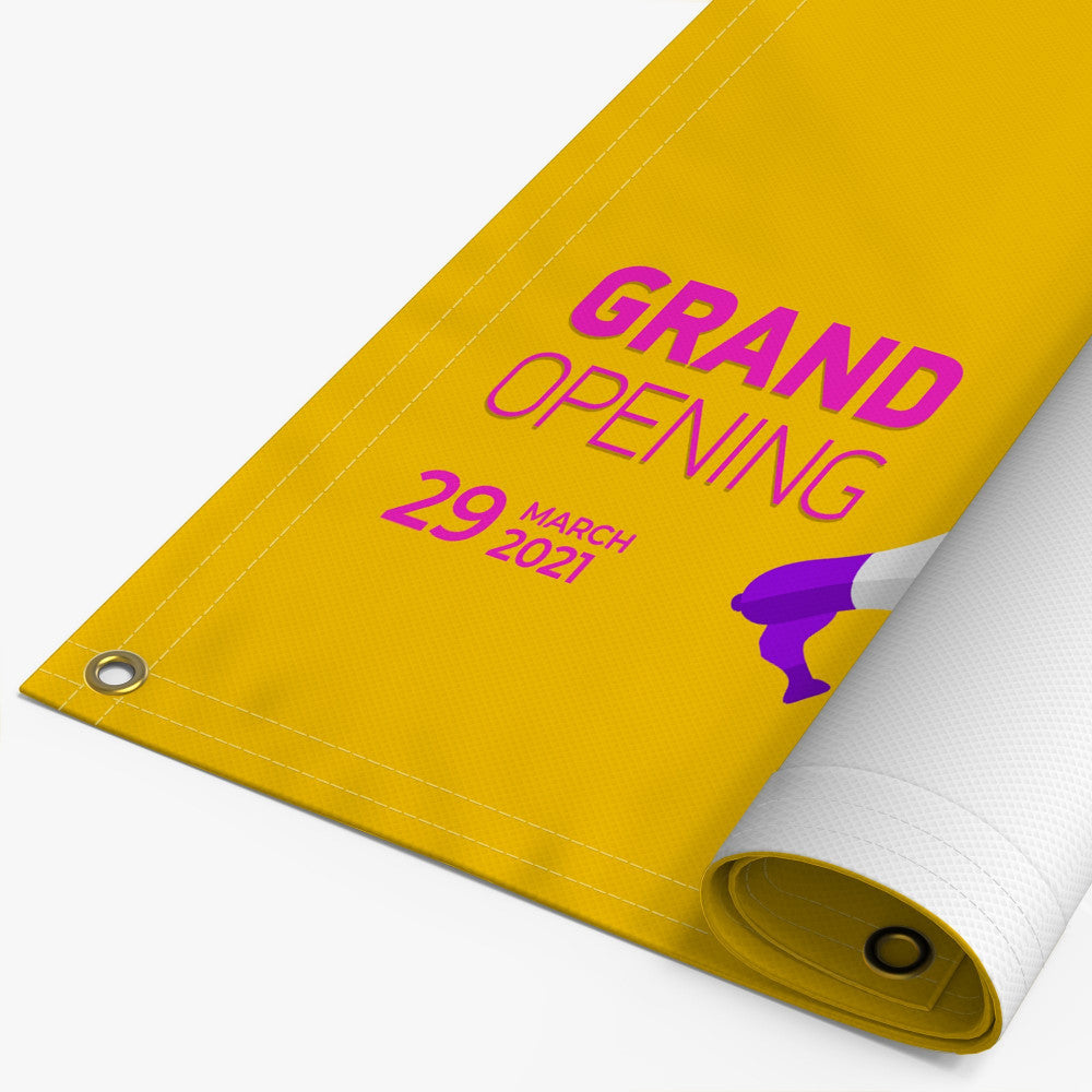 A rolled-up yellow banner with the text 'GRAND OPENING' and a date, indicating a business opening celebration.