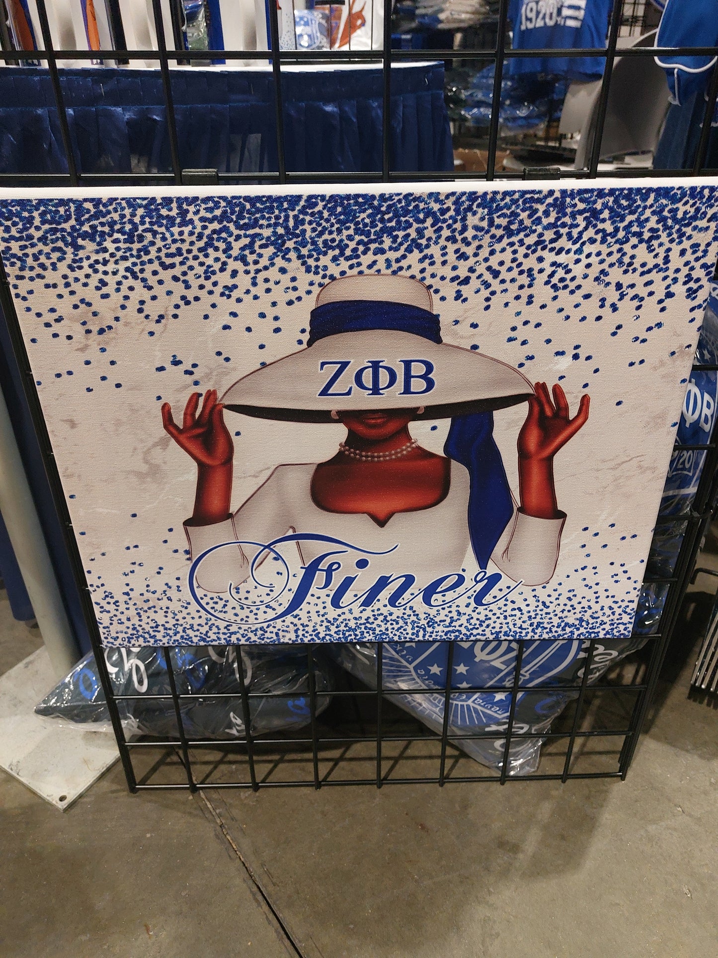 A framed wall art featuring a stylized design of a woman's face wearing a wide-brimmed hat, with the text 'Zeta Phi Beta' and 'Finer' displayed prominently.