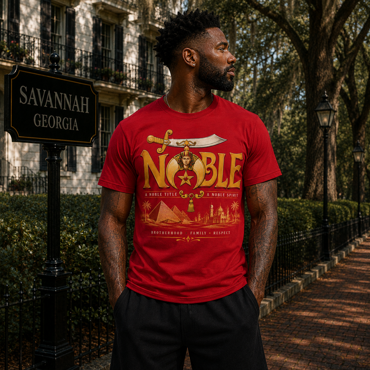 Model wearing the Shriners Noble red T-shirt with gold lettering and Egyptian-inspired emblem
