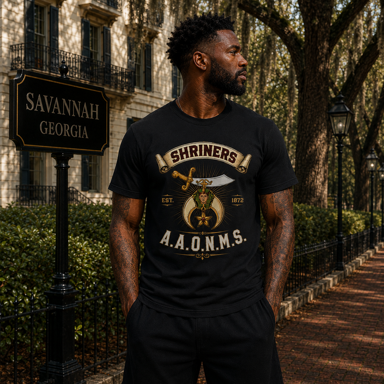 Model wearing the Shriners A.A.O.N.M.S. Heritage black T-shirt with cream, burgundy, and gold artwork