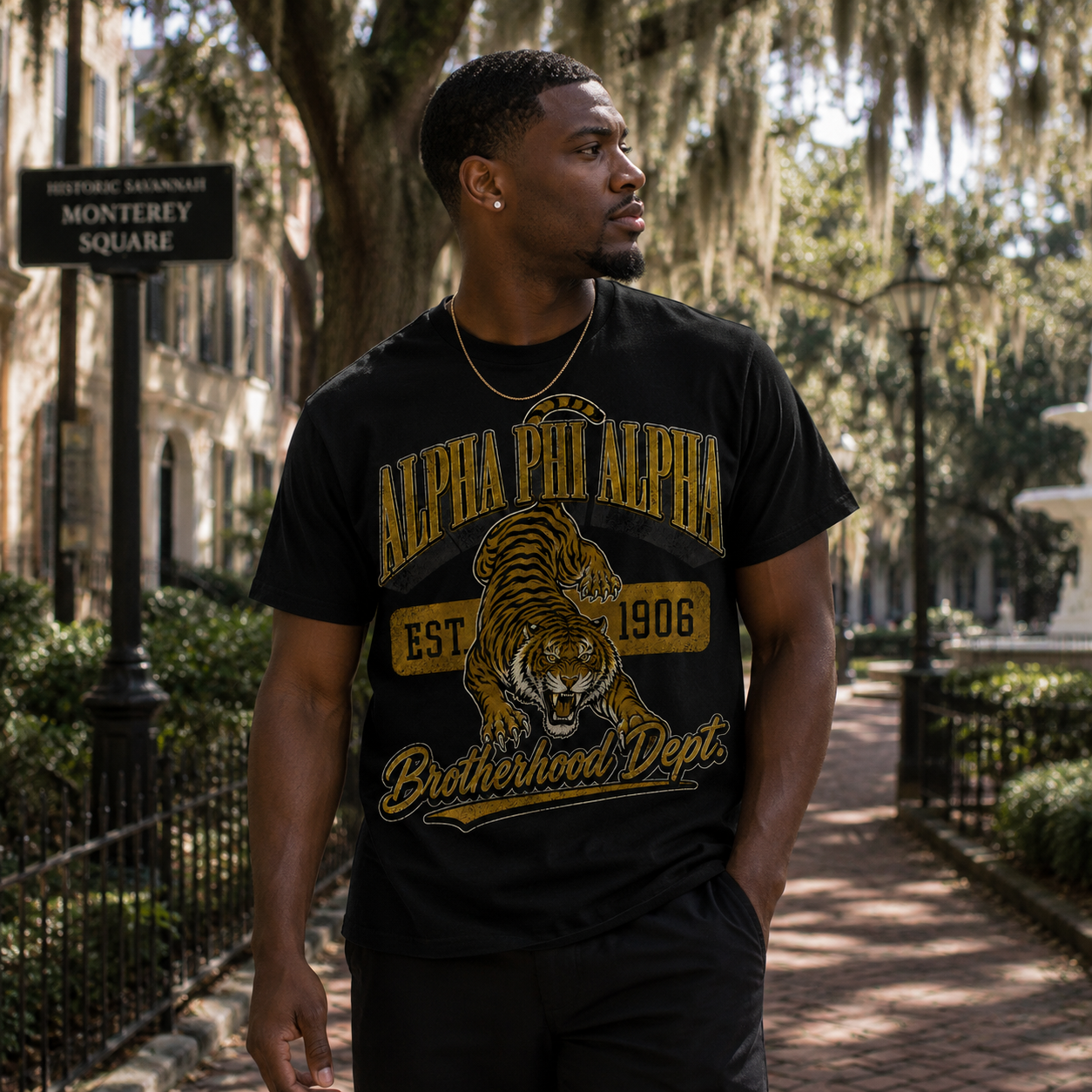 Model wearing the Alpha Phi Alpha Brotherhood Dept. black T-shirt with gold tiger graphic