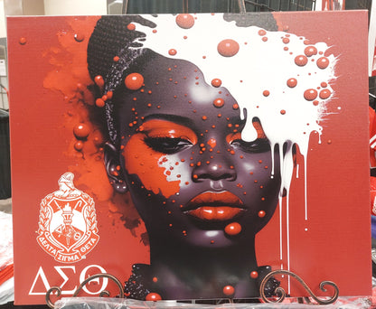 A canvas wall art featuring the Delta Sigma Theta sorority symbol with Greek letters, predominantly red and black with a splash of white paint, mounted on a wooden frame.