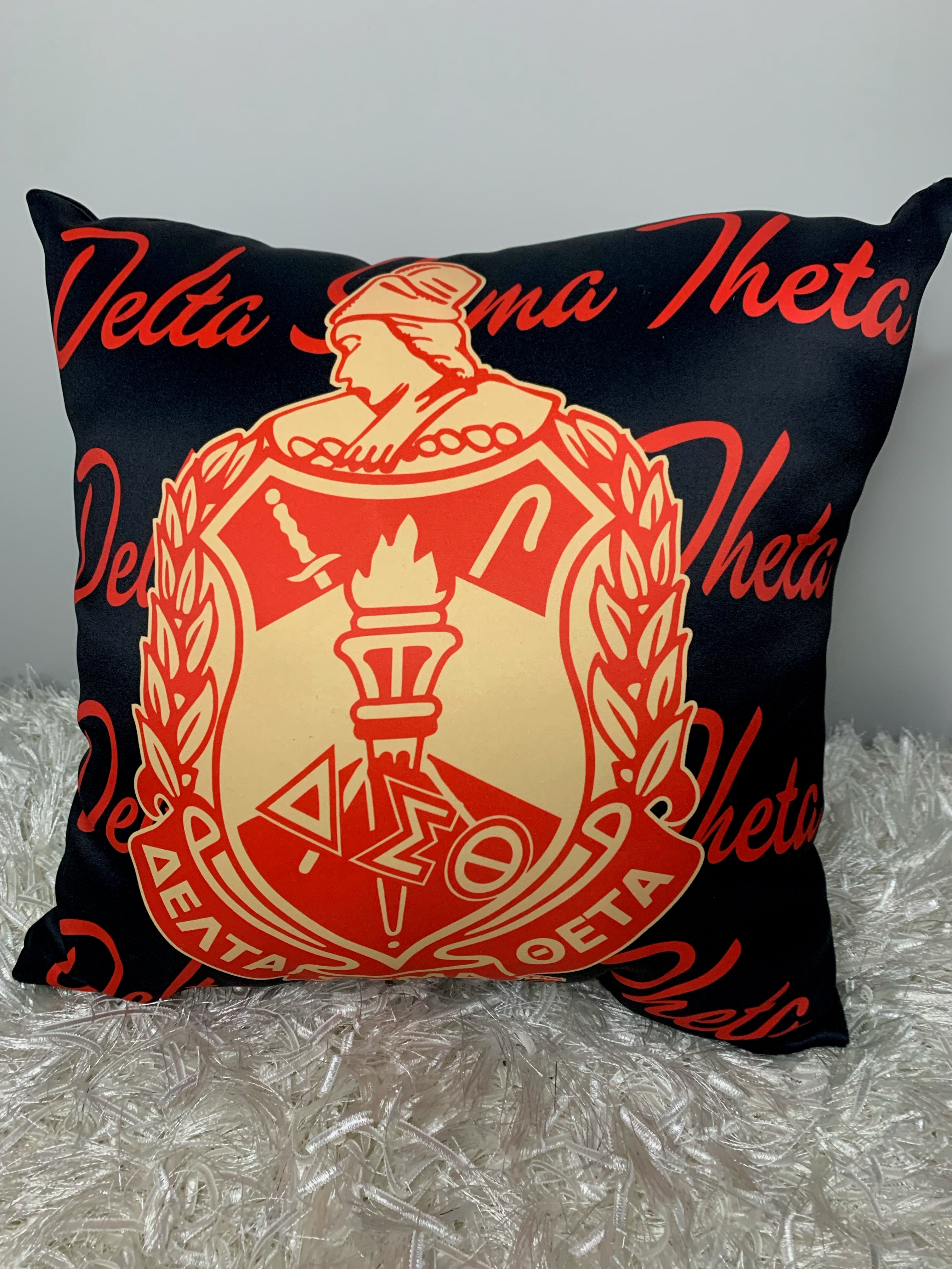 A rectangular pillow with an orange and black color scheme, featuring a geometric design and the text 'DELTA SIGMA THEOLOGICAL'.
